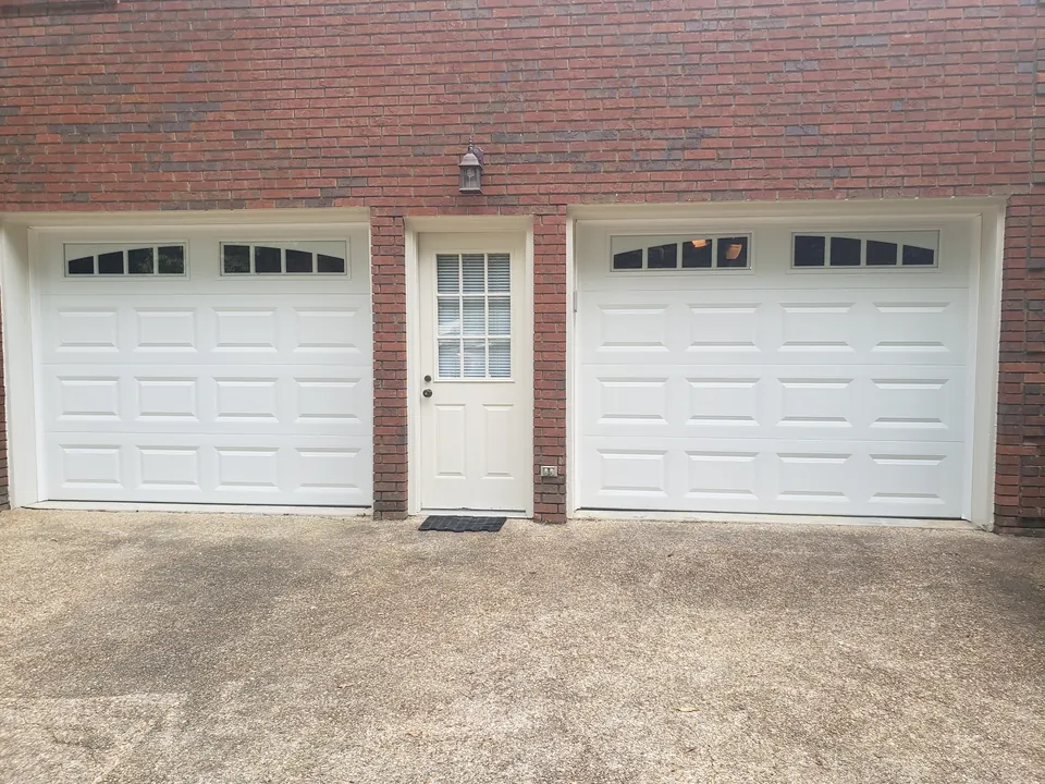 White raised-panel doors with arched windows: a Golden Garage Door Services job